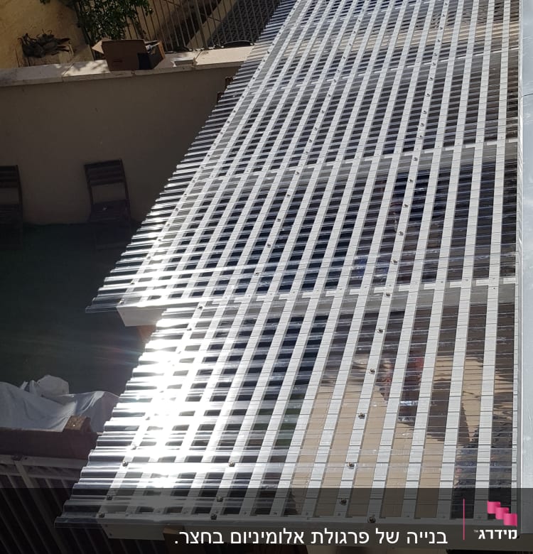 גג פלסטיק שקוף עם מסגרת מתכת, מסור חשמלי צהוב